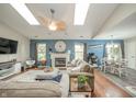 Spacious living room featuring a fireplace, skylights, a ceiling fan, and views of the dining area at 441 E Pine Ridge Dr, Westfield, IN 46074