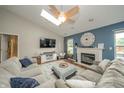 Bright living room with vaulted ceilings, skylights, fireplace, ceiling fan and a large comfortable sectional sofa at 441 E Pine Ridge Dr, Westfield, IN 46074