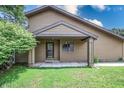 Front door and porch with mature greenery and lawn in the front yard at 4462 Carya Sq, Columbus, IN 47201