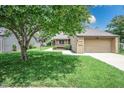A well-maintained home with a one-car garage, lush green lawn, and mature shade tree at 4462 Carya Sq, Columbus, IN 47201