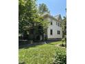 Well-maintained home featuring white siding, mature trees, and a neatly landscaped lawn at 48 N Audubon Rd, Indianapolis, IN 46219