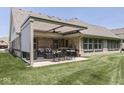 This outdoor back patio offers a covered area with comfortable seating and an outdoor table, perfect for entertaining at 5351 Abbington Ave, Plainfield, IN 46168