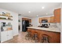 Updated kitchen with granite countertops, bar seating, stainless appliances, and warm wood cabinets at 5625 Winston Dr, Indianapolis, IN 46226