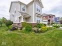 Landscaped front yard featuring a variety of colorful plants and a lush green lawn at 5684 Autumn Trl, Brownsburg, IN 46112