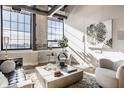 Bright living room with large windows, exposed brick, modern decor, and a plush rug at 630 N College Ave # 409, Indianapolis, IN 46204