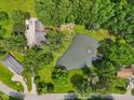Aerial view showcasing the home, its expansive yard, a tranquil pond, and surrounding lush greenery at 6691 N Baltimore Rd, Monrovia, IN 46157