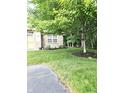 Landscaped yard with fresh green grass, mulch beds, and mature tree near house at 6956 Park Square Dr # D, Avon, IN 46123