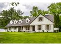 Beautiful exterior of a white home with a well-manicured lawn and a walkway, surrounded by mature trees at 7105 Sylvan Ridge Rd, Indianapolis, IN 46240