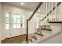 Inviting foyer featuring a staircase with wood and white railings, and a bright, welcoming entrance at 7105 Sylvan Ridge Rd, Indianapolis, IN 46240