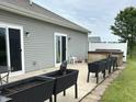 Backyard featuring a cement patio with sliding doors, a hot tub, and black planters at 7611 Cloudy Ct, Camby, IN 46113