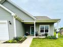 Inviting home exterior featuring manicured landscaping, covered porch, and a secure ADT system at 7611 Cloudy Ct, Camby, IN 46113