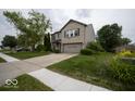 Suburban home featuring a two-car garage, brick facade, and green lawn at 7657 Wheatgrass Ln, Noblesville, IN 46062
