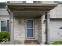 Inviting front porch with brick columns, storm door, and neutral accents at 7657 Wheatgrass Ln, Noblesville, IN 46062
