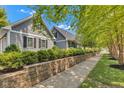 Charming home with beautiful landscaping, stone retaining wall, and gray siding with black shutters at 900 W Busby St, Lebanon, IN 46052