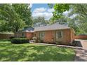 Brick home featuring mature landscaping, creating a serene and private outdoor space at 9014 Holliday Dr, Indianapolis, IN 46260