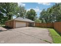 Detached garage with a large driveway, offering ample parking and storage space at 9014 Holliday Dr, Indianapolis, IN 46260