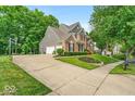 Spacious home with driveway, basketball court, attached garage, and beautifully landscaped front yard at 9834 Belcrest Ln, Indianapolis, IN 46256