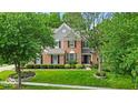 Beautiful brick home with lush landscaping, a well-manicured lawn, and mature trees surrounding the property at 9834 Belcrest Ln, Indianapolis, IN 46256
