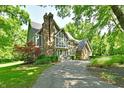 Two-story home with brick and stone exterior, chimney, large windows, and covered entryway at 12380 Creekwood Ln, Carmel, IN 46032