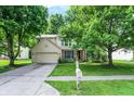 Inviting two-story house with blue shutters, well-kept lawn, and driveway leading to an attached two-car garage at 1264 Black Oak Dr, Greenwood, IN 46143