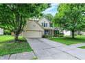Beautiful two-story home featuring green shutters, a two-car garage, and a large front yard with mature trees at 1264 Black Oak Dr, Greenwood, IN 46143