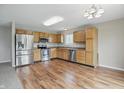 Eat-in kitchen featuring stainless steel appliances, wooden cabinetry, and laminate flooring at 15523 Follow Dr, Noblesville, IN 46060