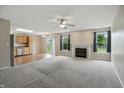 Open-concept living room with a fireplace, ceiling fan, and sliding glass doors to the backyard at 15523 Follow Dr, Noblesville, IN 46060