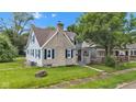 Charming two-story home featuring a stone chimney, blue shutters, and a well-maintained lawn at 1618 Villa Ave, Indianapolis, IN 46203