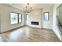 Bright living room featuring wood floors, an electric fireplace, and a modern light fixture at 1654 Fernley Dr, Westfield, IN 46074