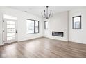 Modern living room boasts lots of natural light, chic chandelier, and sleek hardwood floors at 1654 Fernley Dr, Westfield, IN 46074
