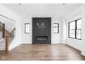 Modern living room featuring hardwood floors, fireplace, and black frame windows offering natural light at 1655 Carrollton Rail Dr, Westfield, IN 46074