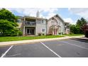 Exterior view of the building with a balcony, parking lot, and well-manicured lawn at 207 Keats Ct # 102, Carmel, IN 46032