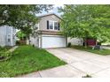 Traditional home with a two-car garage, well-maintained lawn, and established trees at 2270 Collins Way, Greenfield, IN 46140
