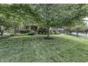 A lush green lawn and mature trees frame the charming exterior of this brick home at 2553 Forest Hills Blvd, Greenwood, IN 46143