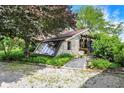 Unique stone home exterior with a sloped glass sunroom addition and gravel yard at 3317 S 100 E, Greenfield, IN 46140