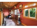 Rustic hallway with wooden walls, a totem pole and door leading to outdoors at 3317 S 100 E, Greenfield, IN 46140
