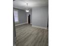 Open-concept living room with gray walls, wood-look flooring, bright window, and modern light fixture at 352 W 28Th St, Indianapolis, IN 46208