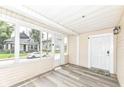 Inviting screened porch featuring light wood-look flooring, white trim and walls, and great natural light at 352 W 28Th St, Indianapolis, IN 46208