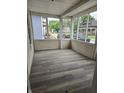 Enclosed porch featuring light-colored siding, lots of windows, and wood-look vinyl plank flooring at 352 W 28Th St, Indianapolis, IN 46208