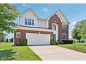A two-story home featuring brick and siding, an expansive driveway, and a meticulously maintained lawn at 4017 Ivory Ct, Carmel, IN 46074