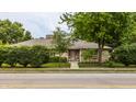 Well-maintained ranch style house surrounded by mature trees and lush green landscaping at 4415 N Illinois St, Indianapolis, IN 46208
