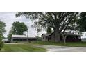 Spacious property featuring a charming home with mature trees, well-manicured lawns, and additional outbuildings at 4849 S 500 E, Greenfield, IN 46140