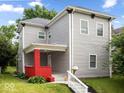 Charming two-story home featuring a red-brick porch, gray siding, and a well-maintained lawn at 4923 E University Ave, Indianapolis, IN 46201