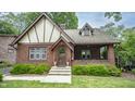 Charming brick Tudor home with arched entry, covered porch, and manicured front yard at 5024 N Kenwood Ave, Indianapolis, IN 46208