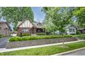 Beautiful Tudor-style home featuring a brick facade, manicured landscaping, and classic design at 5024 N Kenwood Ave, Indianapolis, IN 46208