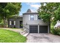 Picture of house featuring a two-car garage, well-kept lawn and mature trees at 5884 Compton St, Indianapolis, IN 46220