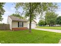 Charming single-story home with a well-maintained lawn, a playground in the background at 6227 Long River Ln, Indianapolis, IN 46221