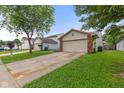 Traditional home with a driveway, two car garage, neat landscaping, and lush green lawn at 6332 Long River Ln, Indianapolis, IN 46221