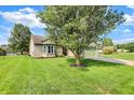 Beautifully landscaped front yard with green lawn, mature tree, and brick exterior details at 6842 Sextant Dr, Indianapolis, IN 46260