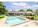 Beautiful backyard with a large in-ground pool, patio furniture, and lush landscaping at 7220 Normandy Way, Indianapolis, IN 46278
